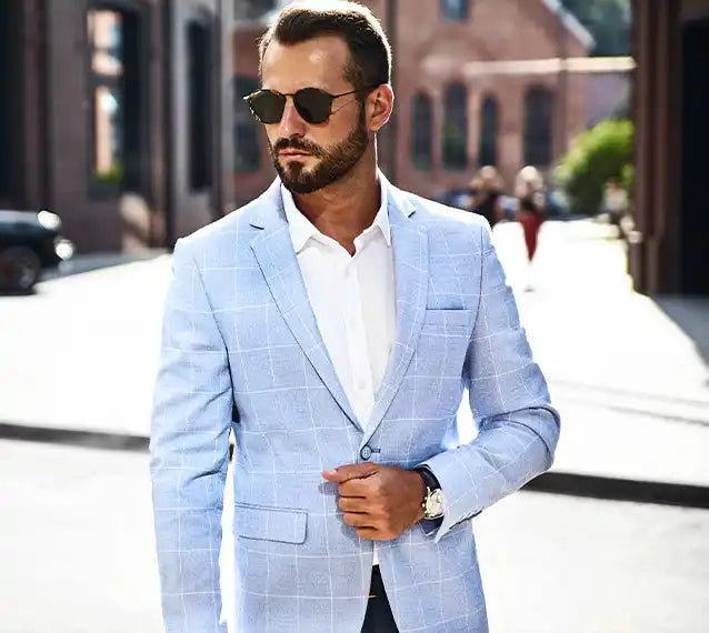 Un blazer a quadri azzurro chiaro con una camicia bianca con bottoni.